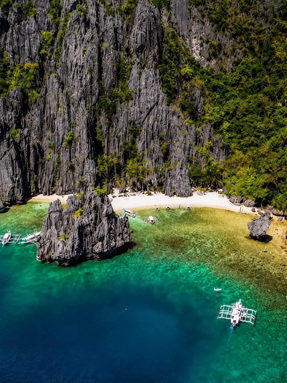 Praia escondida entre formações rochosas e água turquesa nas Filipinas