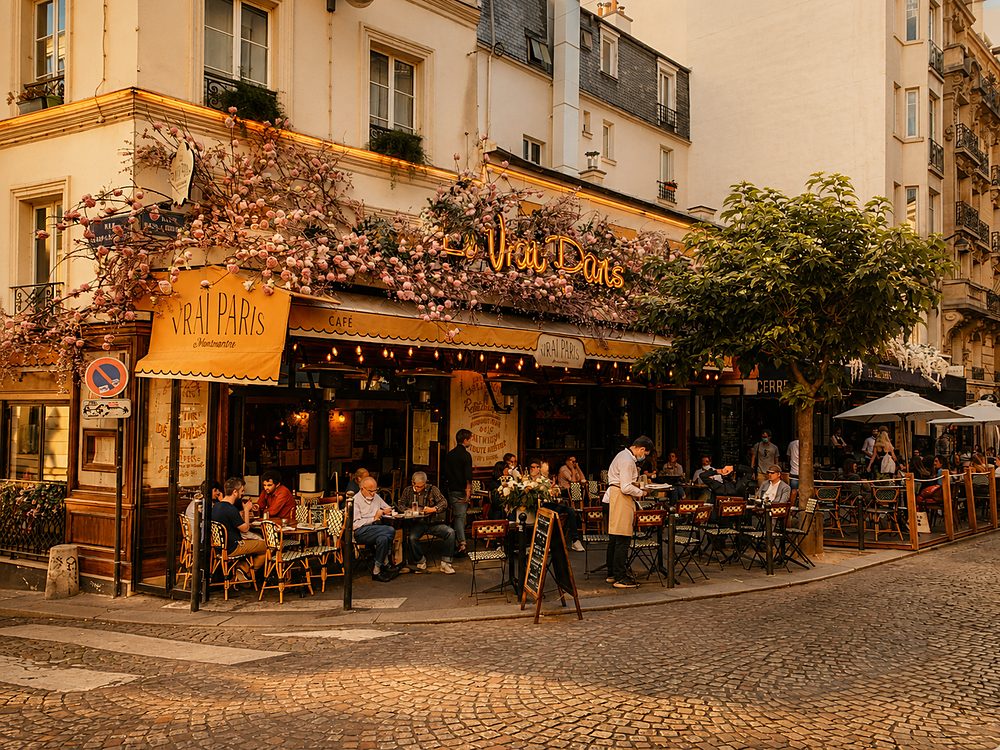 Mesa de café parisiense com croissant, na esquina de um bistrô florido em Paris
